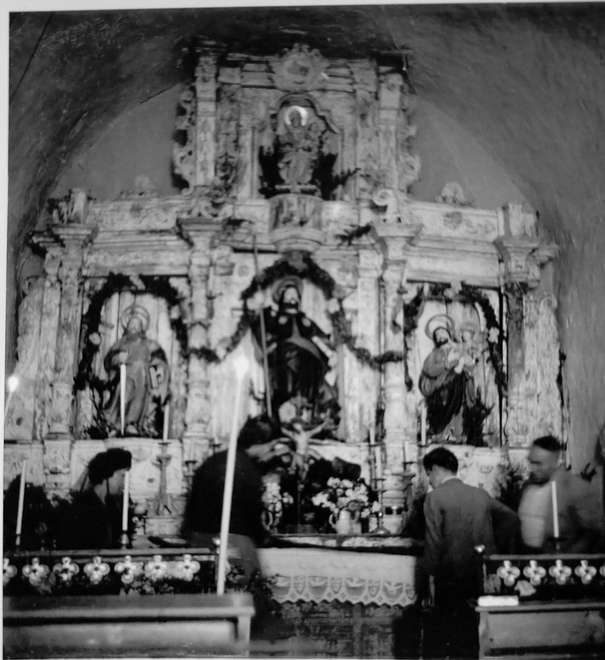 Fotografia antiga en blanc i negre del retaule original de l'ermita de Sant Jaume de la Coma guarnit per la festa
